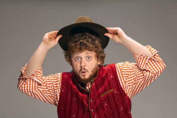 istock Happy smiling man dressed in traditional Austrian or Bavarian costume gesturing isolated on grey studio background 1291763838