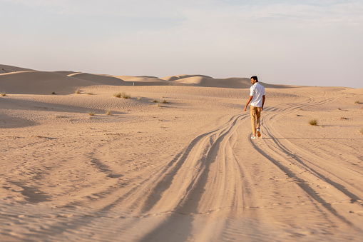 Man walking in a desert at sunrise