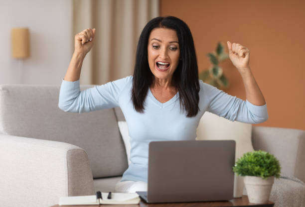 istock Excited mature woman screaming yes using laptop computer 1291766577