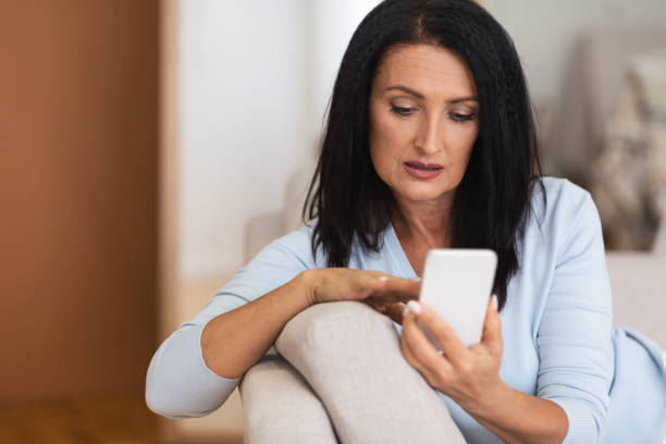 istock Portrait of mature woman using smartphone at home 1291766607