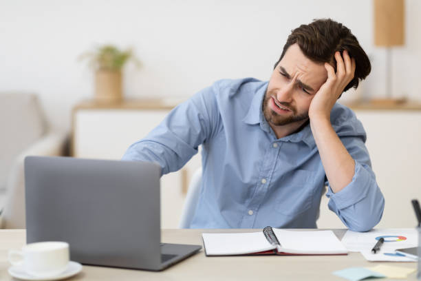 istock Unhappy Man Sitting At Laptop Looking At Screen At Workplace 1291766916