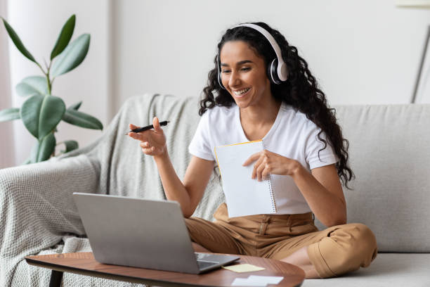 istock Young woman with headset having online conference from home 1291767906