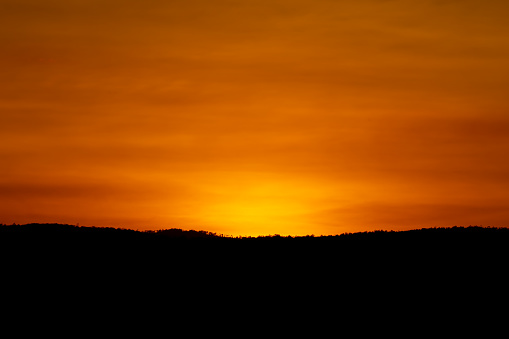 Dark hills on sunset sky background