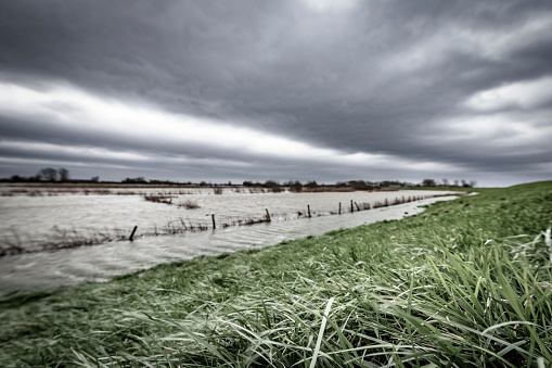 High water level in the river IJssel during a storm with clouds blowing over the landscape near Zwolle in Overijssel, The Netherlands.