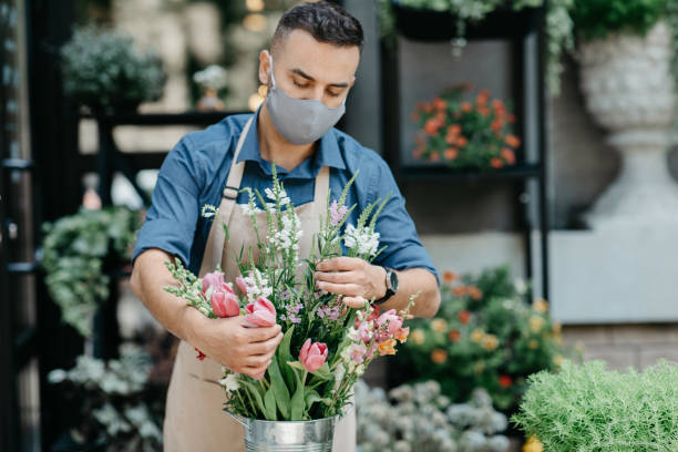 istock Florist making fresh flowers bouquet composition. Millennial small business owner work for client 1291769526