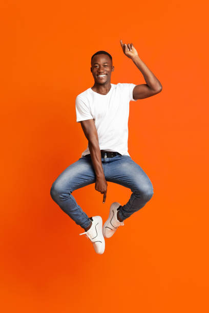 istock Handsome and cheerful african millennial man on orange 1291770119