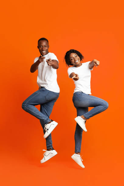 istock Emotional black couple posing on orange studio background 1291771036