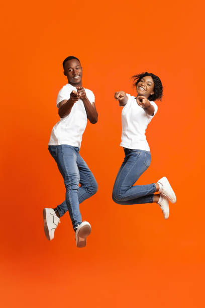 istock Happy black lovers posing on orange studio background 1291771212