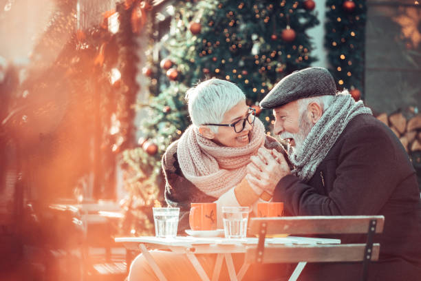 istock Senior couple during Christmas shopping, sit at sidewalk cafe for warming up 1291772821