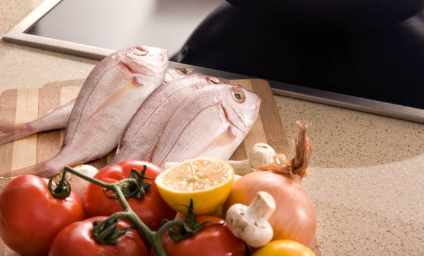 Grilled sea bream cooked over a wood fire. Raw and cooked food.
