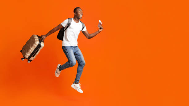 Happy man with passport and suitcase running towards copy space