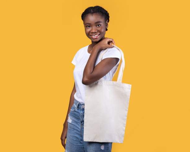 istock African Young Lady Holding White Eco Bag On Yellow Background 1291773104