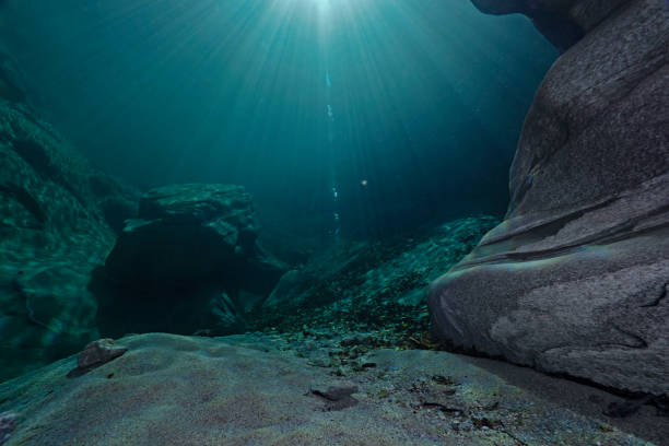 istock Incoming sunlight and light reflections on rocks underwater 1291774188
