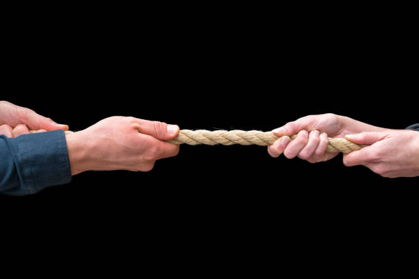 istock Male and female hands pull on a rope as a metaphor for divorce or power relations in a relationship 1291774453