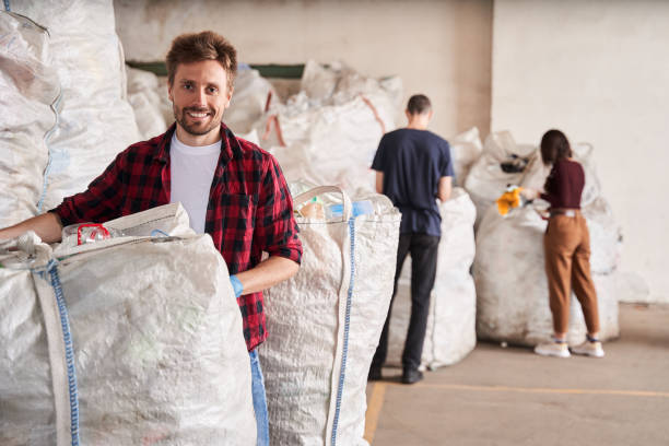 homme souriant à l’appareil-photo tout en restant à son travail - sales manager photos et images de collection