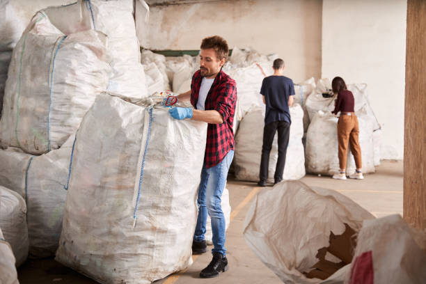 istock Man budges heavy garbage bags 1291778025