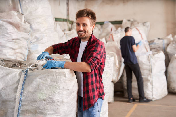 istock Man moving heavy garbage bags 1291778042