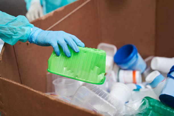 istock Woman holding green crumpled plastic container 1291778089