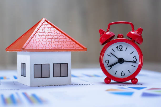 red alarm clock and orange roof house financial concepts, savings, investments in finance, accounting and the stock market spend a good time for investment. - clock time alarm clock orange imagens e fotografias de stock