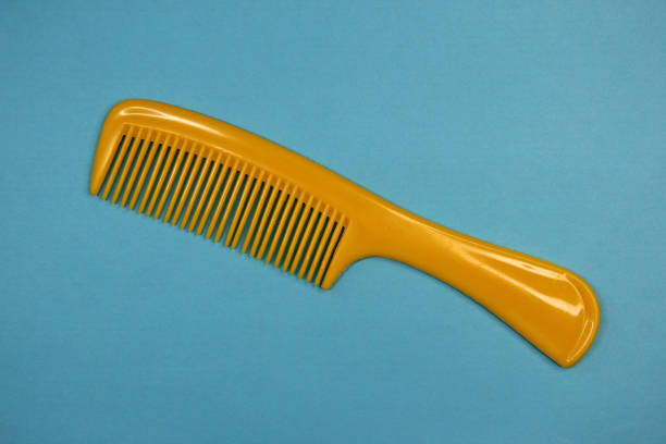 Yellow plastic hairbrush on the blue background