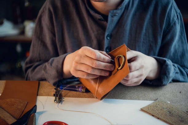 istock A young shoemaker manually sews decorative elements to leather shoes in the workshop 1291783558