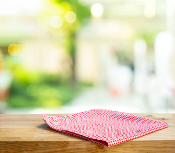 istock Cloth napkin on wood table with glass window background 1291784494