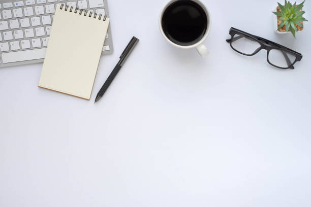 istock White office desk table with keyboard, notebook and coffee cup with equipment other office supplies. Business and finance concept. Workplace, Flat lay with blank copy space. Top view 1291784635