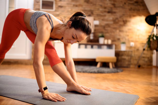 istock Smiling female athlete doing stretching exercises during home workout. 1291787353