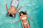 Smiling couple floating in pool