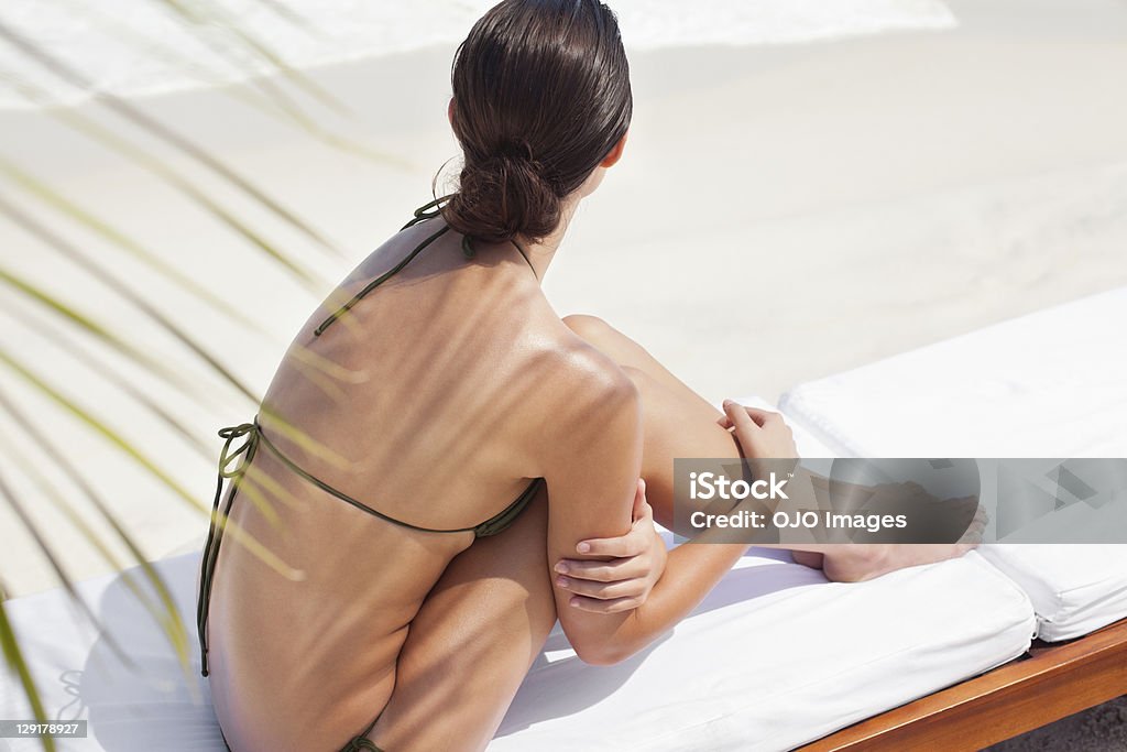 Vista de alto ângulo de uma adolescente sentado à beira da piscina - Foto de stock de Fotografia - Imagem royalty-free