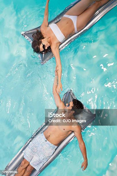 Couple In Swimming Pool Lying On Raft Stock Photo - Download Image Now - Swimming Pool, Pool Raft, Boyfriend