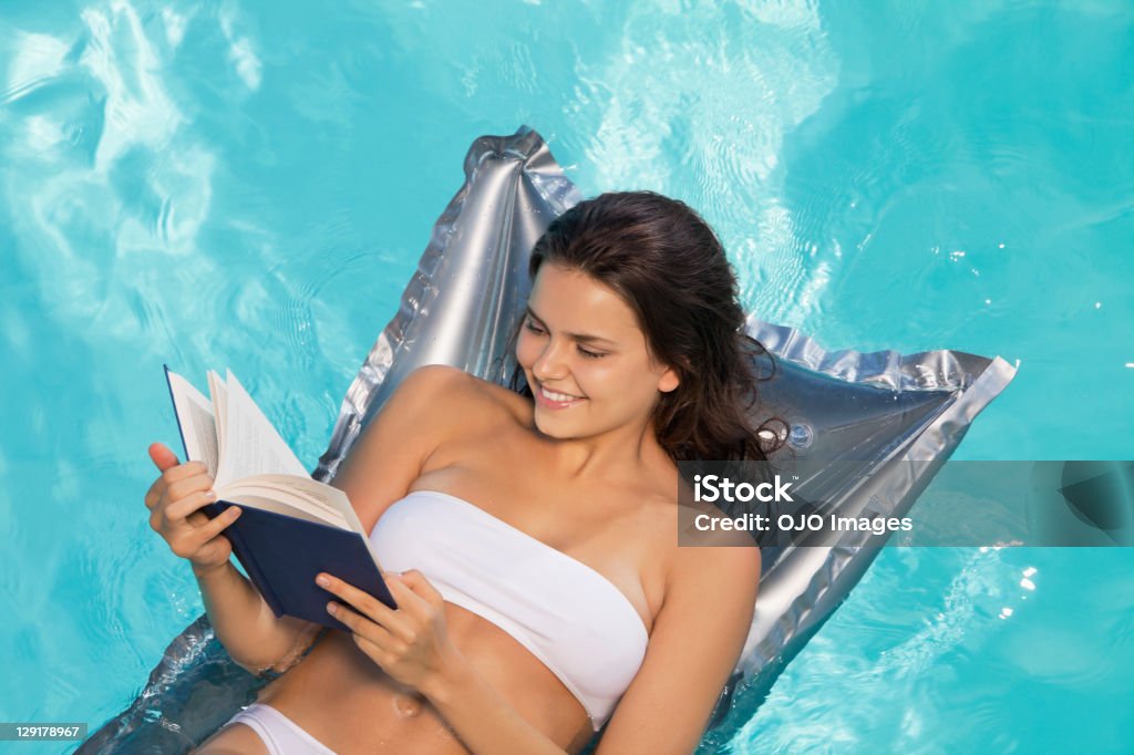 Plan de plongée d'une femme souriante lisant livre - Photo de Bikini libre de droits