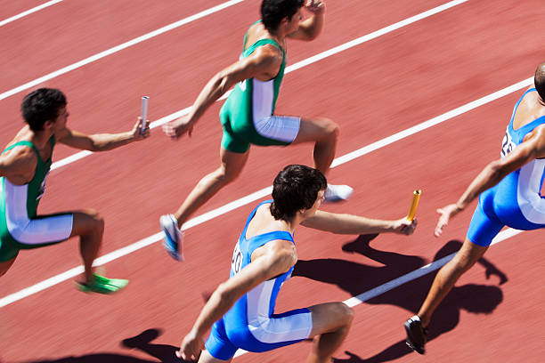 maschio runner passa staffetta - atleta di atletica leggera foto e immagini stock