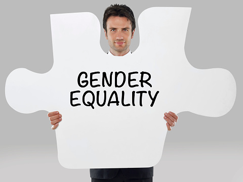 Businessman holding a missing piece of a puzzle with “Gender equality” text