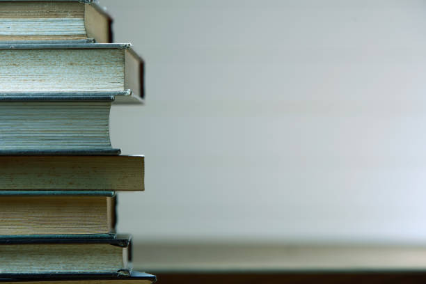 istock Stack of books on a wooden school desk against wall 1291793198