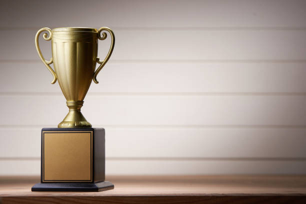 istock trophy on wooden table against white wall 1291793331
