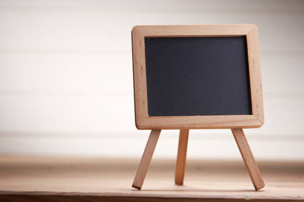 istock mini blackboard on wood table against white wall 1291793336
