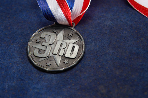 bronze medal bronze medal with ribbon on blue background Third Place stock pictures, royalty-free photos & images