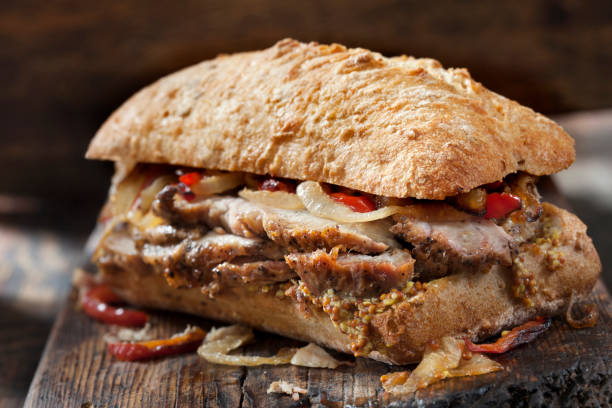 сэндвич с жареной свининой с жареным перцем, луком и зернистой горчицей на хлебе чиабатта - pork roast pork roasted meat стоковые фото и изображения