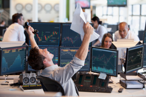 Close-up on a business man celebrating a successful investment on the stock market and watching growth graphs on a laptop