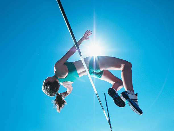 atleta compensación salto de altura femenino - salto de altura fotografías e imágenes de stock