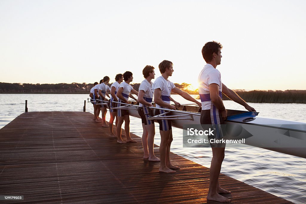 Vista lateral de hombres sosteniendo una embarcación - Foto de stock de Deporte libre de derechos