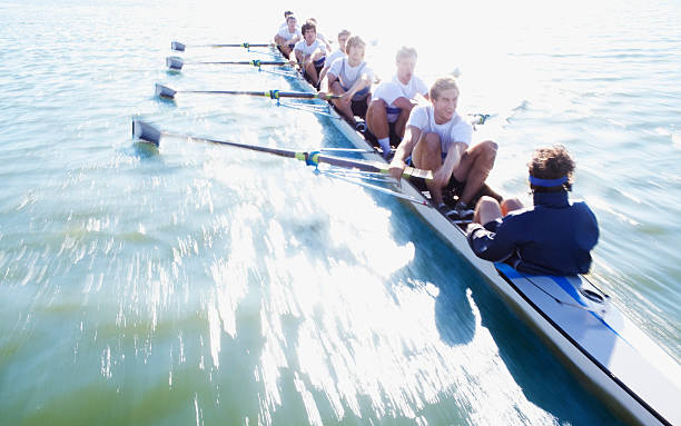 hombres en fila de botes oaring - rowing fotografías e imágenes de stock