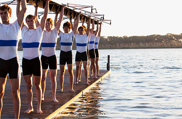 atletas segurando uma equipe de chefes de canoa - rowing team sport team sport rowing - fotografias e filmes do acervo