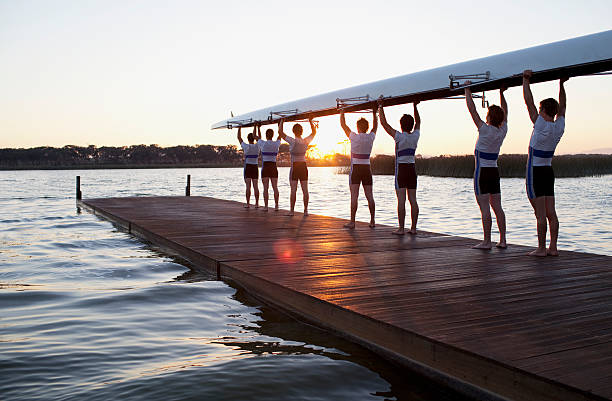 hombres sosteniendo canoa con cabezales - rowing fotografías e imágenes de stock