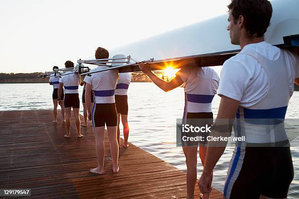 Foto de Homens Segurando Canoa Sobre Os Ombros e mais fotos de stock de Barco a remo - Barco a remo, Canoa, Equipe Esportiva