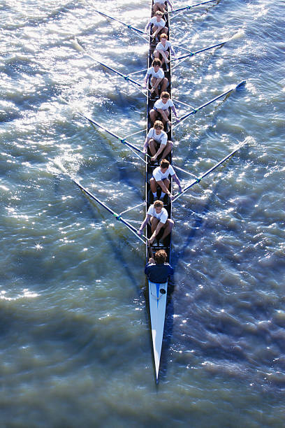 vue en plongée du peuple long en canoë - team sports team rowing teamwork photos et images de collection