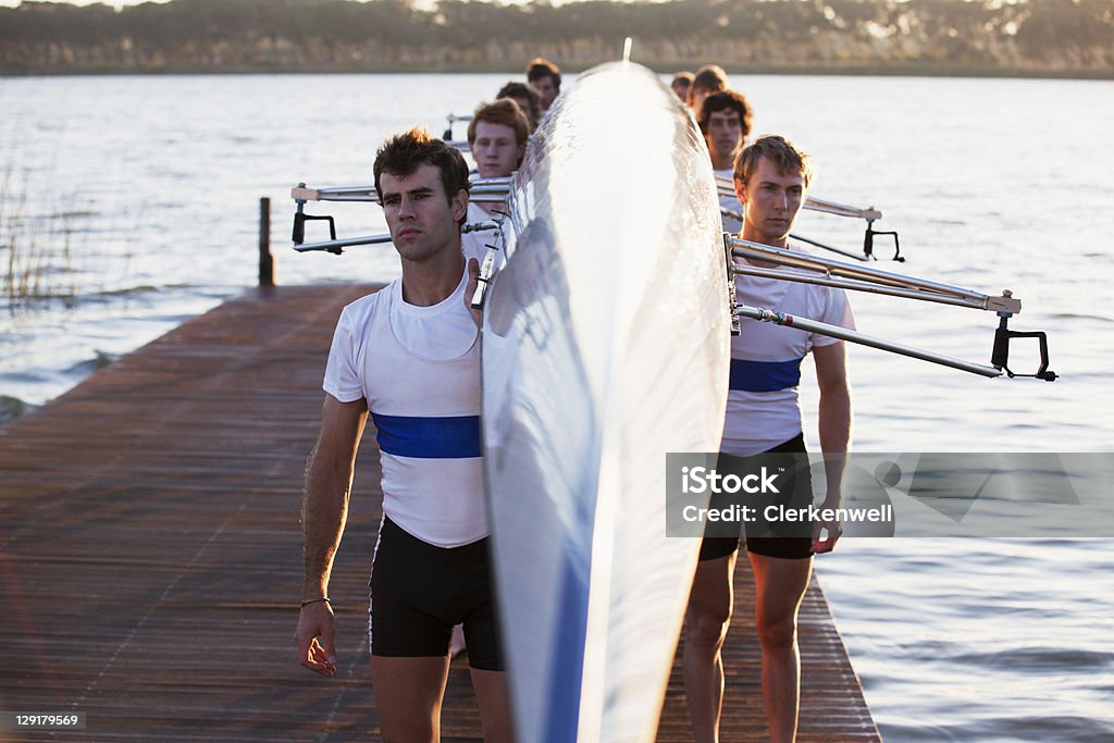 Hombres en el muelle sobre sus hombros canoa de transporte - Foto de stock de 18-19 años libre de derechos