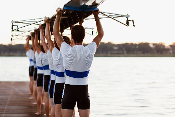 team dei canottieri portare una doppia canoa su capi - team sport foto e immagini stock