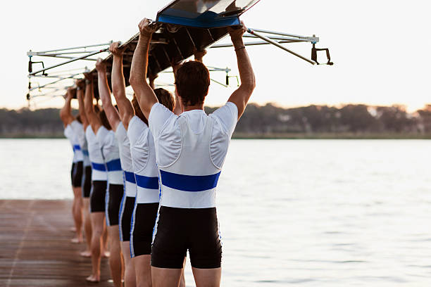 Team of rowers carrying a crew canoe over heads  team sport stock pictures, royalty-free photos & images